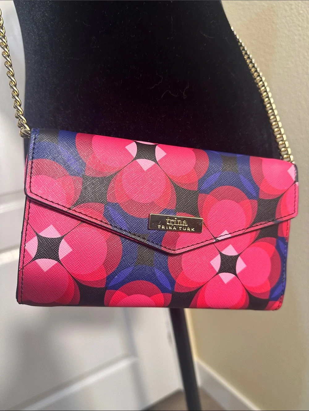 Trina Turk pink, red, black and blue cross body clutch with gold tone chain